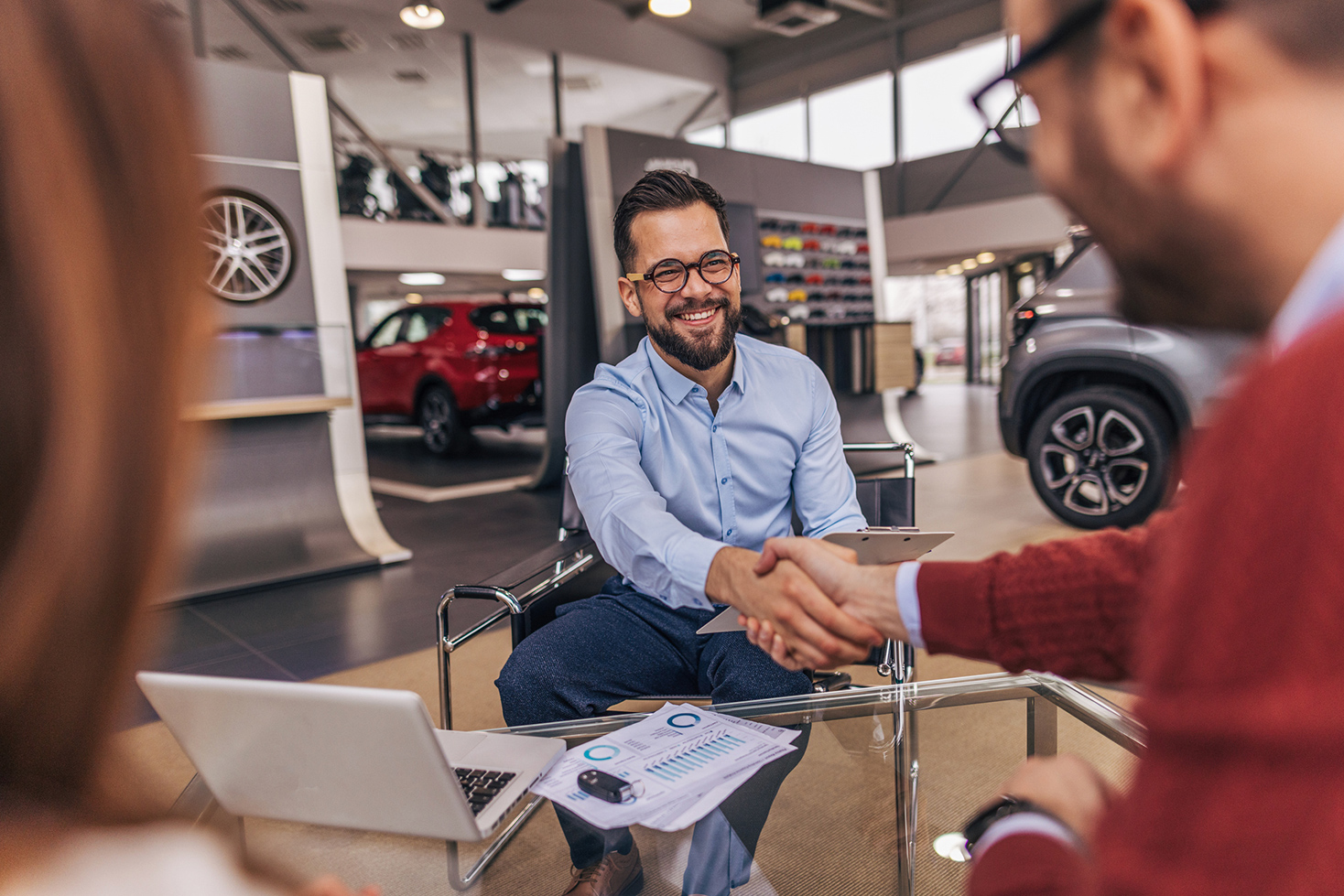 Guidatore che restituisce l'auto alla fine del noleggio a lungo termine stringendo la mano